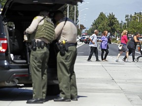 People are evacuated as Los Angeles County Sheriff's deputies prepare to stand guard at Kaiser Permanente Downey Medical Center, following reports of someone with a weapon at the facility in Downey, Calif., Tuesday, Sept. 11, 2018. Los Angeles County sheriff's officials say a suspect is in custody and deputies and police officers are methodically searching the complex.