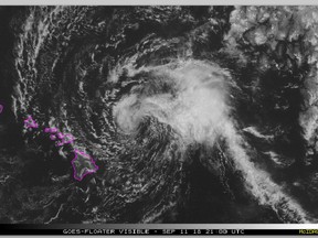 This satellite image made available the National Oceanic and Atmospheric Administration (NOAA) shows Tropical Storm Olivia east of the main islands of Hawaii at 11 a.m. Hawaii time Tuesday, Sept. 11, 2018. Central Pacific Hurricane Center meteorologist Matthew Foster says the storm could deposit 10 to 15 inches of rain on the islands, though some areas could get as much as 20 inches. (NOAA via AP)