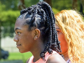 FILE - In this Friday, Aug. 24, 2018, file photo, Faith Fennidy walks to a news conference outside the offices of attorney James Williams, in Metairie, La.  Parents of two New Orleans-area school girls have dismissed their lawsuit against a Catholic school, Monday, Sept. 10,  over its policy forbidding hair extensions.  Christ the King school rescinded the policy late last month amid accusations that it was discriminatory against black students.  The school and the Archdiocese of New Orleans drew widespread online outrage after video spread of Fennidy tearfully leaving school after being told her hair style violated the policy.