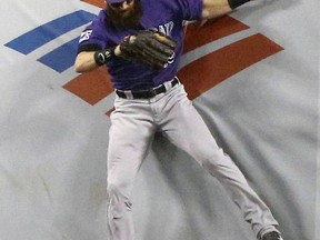 Colorado Rockies center fielder Charlie Blackmon leaps but cannot catch a fly ball hit to the fence by Los Angeles Dodgers' Manny Machado during the first inning of a baseball game in Los Angeles, Tuesday, Sept. 18, 2018.