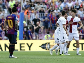 Barcelona's Lionel Messi, left, watches as Huesca's Cucho celebrates scoring the first goal of the game during a Spanish La Liga soccer match between Barcelona and Huesca at the Camp Nou stadium in Barcelona, Spain, Sunday Sept. 2, 2018.