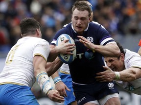 FILE - In this Saturday, March 17, 2018 file photo, Scotland's Stuart Hogg, centre, is tackled by Italy's Sebastian Negri, left, and Alessandro Zanni during the Six Nations rugby union match between Italy and Scotland at Rome's Olympic stadium. Fullback Stuart Hogg is set to miss Scotland's four November rugby tests following ankle surgery which will sideline him for up to three months.