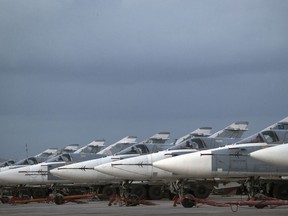 FILE- In this file photo dated Friday, March 4, 2016, Russian warplanes are parked at Hemeimeem air base in Syria.  A Russian reconnaissance aircraft was brought down over the Mediterranean Sea as it was returning to its home base inside Syria, killing all 15 people on board, the Russian defense ministry said Tuesday Sept. 18, 2018.
