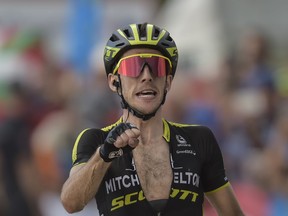 FILE - In this Saturday, Sept. 8, 2018 file photo, Mitchelton-Scott's Team Simon Yates of Britain celebrates after winning  the 14th stage between Cistierna and Les Praeres Nava, 171 kilometers (106,25 miles), of the Spanish Vuelta cycling race that finishes in Les Praeres Nava, northern Spain. Yates is poised to win his first Grand Tour title after he successfully defended his lead of the Spanish Vuelta through the 20th stage. Yates will take his advantage of 1 minute, 46 seconds, over Enric Mas into the final stage, when race custom dictates the riders don't attack the race leaders on the traditional arrival to Madrid.