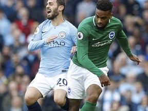 Manchester City's Bernardo Silva, left, in action with Brighton & Hove Albion's Jurgen Locadia, during their English Premier League soccer match at the Etihad Stadium in Manchester, England, Saturday Sept. 29, 2018.