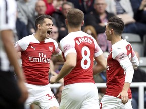 Arsenal's Granit Xhaka, left, celebrates scoring his side's first goal of the game with teammates, during the English Premier League soccer match between Newcastle United and Arsenal at St James' Park, in Newcastle, England, Saturday, Sept. 15, 2018.