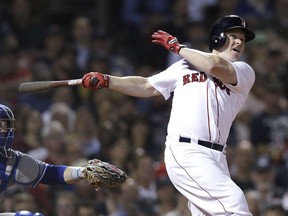 Boston Red Sox's Brock Holt follows through on his pinch-hit, three run home run off Toronto Blue Jays relief pitcher Ryan Tepera during the seventh inning of a baseball game at Fenway Park in Boston, Tuesday, Sept. 11, 2018. At left is Toronto Blue Jays catcher Danny Jansen.
