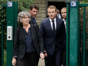 French President Emmanuel Macron (C) walks next to Michele Audin, daughter of late Maurice Audin, as he leaves the home of Josette Audin, widow of Audin, on September 13, 2018 in Bagnolet. - President Emmanuel Macron acknowledged that mathematician Maurice Audin, a Communist pro-independence activist who disappeared in 1957, "died under torture stemming from the system instigated while Algeria was part of France", his office said.