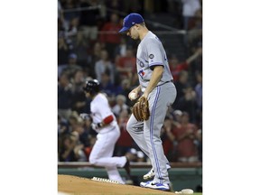 Toronto Blue Jays starting pitcher Sam Gaviglio, right, looks down as Boston Red Sox's J.D. Martinez rounds third on a solo home run in the second inning of a baseball game at Fenway Park, Thursday, Sept. 13, 2018, in Boston.