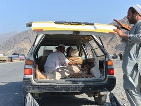 Men carry a dead body with a civilian vehicle in Momandara district of Nangarhar province, Afghanistan, Tuesday, Sept. 11, 2018.