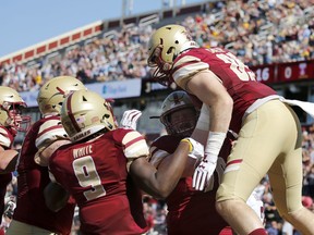 Boston College tight end Tommy Sweeney is lifted by teammates after scoring a touchdown during the first half of an NCAA college football game against Temple, Saturday, Sept. 29, 2018, in Boston.