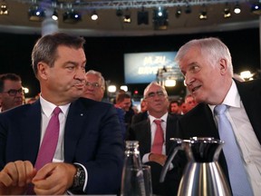 Bavarian State Governor Markus Soeder, left, talks to German Interior Minister Horst Seehofer, right, prior to a party convention of the German Christian Social Union party in Munich, Germany, Saturday, Sept. 15, 2018.
