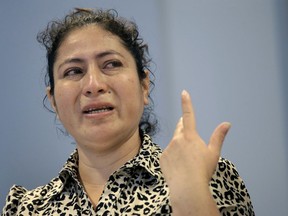 A mother from Guatemala, identified only by initials L.J., who was separated from her two children after entering the U.S. in May of 2018, is tearful while speaking to reporters about the separation during a news conference, Thursday, Sept. 6, 2018, in Boston. L.J. is among plaintiffs in a lawsuit against President Donald Trump's administration, seeking monetary damages on behalf of children who were separated from their parents at the border.