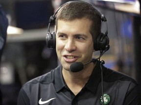 Boston Celtics head coach Brad Stevens wears earphones during an interview at NBA basketball media day, Monday, Sept. 24, 2018, in Canton, Mass.