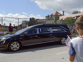 People watch as the funeral procession for Sen. John McCain, R-Ariz., arrives at the United States Naval Academy in Annapolis, Md., Sunday, Sept. 2, 2018, for his funeral service and burial. McCain died Aug. 25 from brain cancer at age 81.