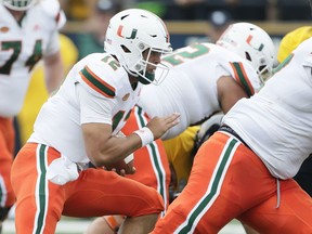 Miami quarterback Malik Rosier (12) carries for a touchdown behind his blockers during the first quarter of an NCAA college football game against Toledo Saturday, Sept. 15, 2018, in Toledo, Ohio.