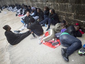 Migrants sleep in police stations as they await to be transported to a police station in Algeciras.