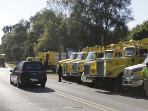 In this Sunday, Sept. 23, 2018, photo the hearse carrying Justin Pratt proceeds past sanitation trucks during the funeral procession to honor the sanitation worker in Grass Lake, Mich.