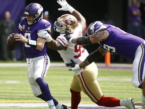 Minnesota Vikings quarterback Kirk Cousins, left, is sacked by San Francisco 49ers defensive end DeForest Buckner (99) during the first half of an NFL football game, Sunday, Sept. 9, 2018, in Minneapolis.