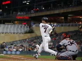 Minnesota Twins' Joe Mauer follows through on a base hit against the Detroit Tigers during a baseball game Tuesday, Sept. 25, 2018, in Minneapolis.