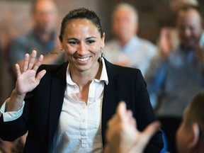 FILE - In this Aug. 8, 2018, file photo, Democrat Sharice Davids waves at her supporters at a Democratic event in Kansas City, Kan. Republican Rep. Kevin Yoder and his Democratic challenger, Davids are having a hard time keeping their political footing on immigration issues, complicating their efforts to win a competitive swing district in Kansas that President Donald Trump narrowly lost.