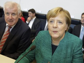 Christian Democratic Union Chairwoman and German Chancellor Angela Merkel, right, and Bavarian's Christian Social Union chairman and German Interior Minister Horst Seehofer, left, attend a faction meeting of their ruling Christian Union parties at the Reichstag building in Berlin, Tuesday, Sept. 25, 2018.
