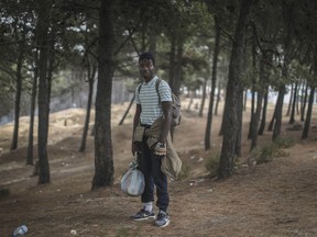 In this Saturday, Sept. 8, 2018 photo, Alex Brandan, a Cameroonian migrant, poses for a portrait as he takes shelter in a forest near Masnana, on the outskirts of Tangier, Morocco. Hundreds of sub-Saharan migrants escaping poverty and violence in their home countries are fleeing to forests to escape police raids in the northern Moroccan port city of Tangiers _ only to be chased from their makeshift camps. Migrants have been arriving in Morocco in increasing numbers in a bid to get to Spain via the Strait of Gibraltar. A prime route from Libya to Italy is being choked, notably by the Libyan coast guard intercepting smugglers' boats.