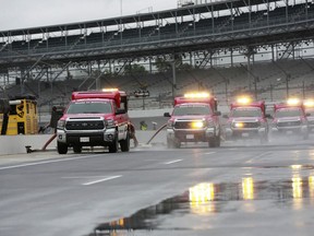 Track driers work to dry the pit lane before the NASCAR Brickyard 400 auto race at Indianapolis Motor Speedway, in Indianapolis Sunday, Sept. 9, 2018.