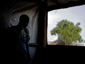 FILE - In this Saturday, June 3, 2017 file photo, a South Sudanese refugee and 32-year-old mother, who was raped for several days by a group of soldiers before she was allowed to leave, stands by a window at a women's center focusing on gender-based violence, run by the aid group International Rescue Committee, in Bidi Bidi, Uganda. A new report by Amnesty International released Wednesday, Sept. 19, 2018 says South Sudan government soldiers and allied militia targeted civilians by raping them, burning them alive, running them over with armored vehicles and hanging them in trees.