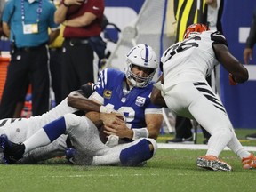 Indianapolis Colts quarterback Andrew Luck (12) is tackled by Cincinnati Bengals defensive end Michael Johnson (90) and defensive back Shawn Williams (36) during the first half of an NFL football game in Indianapolis, Sunday, Sept. 9, 2018. Williams was disqualified for his hit on Luck.