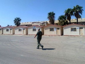 In this photo released by the Syrian official news agency SANA, a Syrian soldier walk inside the Naseeb crossing point with Jordan, Syria, Saturday, Sept 29, 2018. Preparations to reopen a vital border crossing between Syria and Jordan have been completed, setting the stage for its reopening on Oct. 10, Syria's state-run news agency said Saturday.