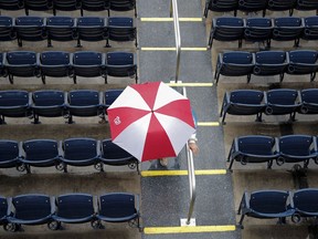 A fan with a Washington Nationals umbrella walks from Nationals Stadium during a rain delay of a baseball game between the Nationals and the Chicago Cubs, Sunday, Sept. 9, 2018, in Washington.