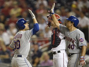 New York Mets' Michael Conforto, left, celebrates his two-run home run with Jason Vargas (40), next to Washington Nationals catcher Matt Wieters during the third inning of a baseball game Thursday, Sept. 20, 2018, in Washington.