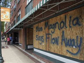 Storefronts have wood paneling installed over windows, Tuesday, Sept. 11, 2018, in New Bern, N.C., as a  precaution against storm damage from Hurricane Florence.