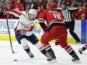 Washington Capitals' Nicklas Backstrom (19), of Sweden, skates against Carolina Hurricanes' Dougie Hamilton during the first period of a preseason NHL hockey game in Raleigh, N.C., Friday, Sept. 21, 2018.