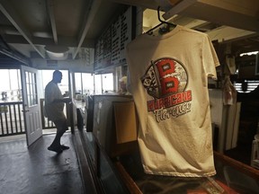 A tee-shirt hangs inside the Avalon Fishing Pier as a man buys coffee in Kill Devil Hills, N.C., Thursday, Sept. 13, 2018 as Hurricane Florence approaches the east coast.