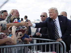 President Donald Trump greets guests on the tarmac upon his arrival on Air Force One at Charlotte Douglas International Airport, Friday, Aug. 31, 2018 in Charlotte, N.C.