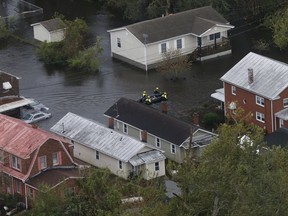 Rescue personnel use a small boat as they go house to house checking for flood victims from Florence in New Bern, NC., Saturday, Sept. 15, 2018.