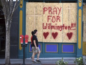 People walk by the boarded up front windows of Bourbon Street in preparation for Hurricane Florence in Wilmington, N.C., Wednesday, Sept. 12, 2018. The effects of Hurricane Florence in Southeastern North Carolina are expected to begin Thursday.