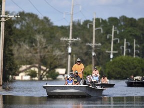 Area residents ride down N.C. Highway 53 that is flooded from the Northeast Cape Fear River in Burgaw, N.C., Wednesday, Sept. 19, 2018. The river had severe flooding due to the rains from Hurricane Florence.