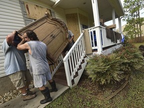 Richard Lombardi, Chris Barber and Gary Barber move furniture from Lombardi's home that was damaged by Hurricane Florence Tuesday Sept. 18, 2018 in Boiling Spring Lakes,N.C.
