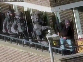 In this image made from video provided by the Netherlands Police, armed police prepare for an operation in a residential area in Arnhem, Netherlands, Thursday, Sept. 27, 2018.