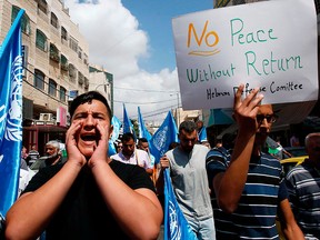 Palestinians protest the U.S. cut in funding for the United Nations Relief and Works Agency (UNRWA) in the West Bank town of Hebron on Sept. 8, 2018.