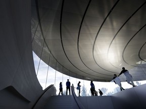 People wait outside of the Steve Jobs Theater before an event to announce new Apple products Wednesday, Sept. 12, 2018, in Cupertino, Calif.