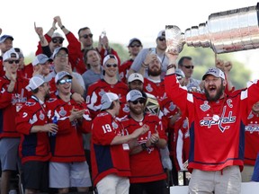 FILE - In this June 12, 2018, file photo, Washington Capitals' Alex Ovechkin, from Russia, right, holds up the Stanley Cup during a victory rally in Washington. The celebrating is over for now for the Capitals after partying as hard as any champion in NHL history. When they get the ice for the first practices of training camp Friday, they're just one of 31 teams again but bear the burden of trying to move past the first victory summer for almost every player on the roster.