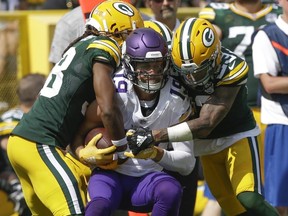 FILE - In this Sunday, Sept. 16, 2018 file photo, Minnesota Vikings' Adam Thielen catches a pass between Green Bay Packers' Tramon Williams and Jaire Alexander during the first half of an NFL football game in Green Bay, Wis. The game finished 29-29. The NFL reduced the length of overtime from 15 minutes to 10 before last season.
