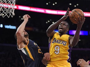 FILE - In this Tuesday, Dec. 27, 2016 file photo, Los Angeles Lakers forward Luol Deng, right, shoots as Utah Jazz center Rudy Gobert defends during the first half of an NBA basketball game in Los Angeles. The Minnesota Timberwolves have signed free agent forward Luol Deng, the latest former Chicago Bulls player to reunite with coach Tom Thibodeau. Deng's one-year deal is for $2.4 million, according to a person with knowledge of the contract speaking on condition of anonymity to The Associated Press because the team does not release terms