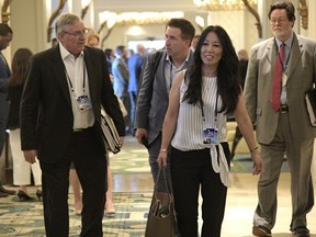 FILE - In this March 26, 2018, file photo, Buffalo Bills owners Terry, left, and Kim Pegula, front, leave a conference room during the NFL owners meetings in Orlando, Fla. Kim Pegula tells The Associated Press the clock on deciding whether to build a new stadium or renovate the team's current facility won't begin ticking until after New York's gubernatorial race is settled in November. Pegula describes that timetable as being "prudent" because the Bills don't want a stadium-funding issue to become a distraction during the election.