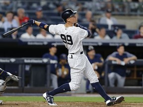 FILE - In this July 7, 2017, file photo, New York Yankees Aaron Judge watches his fifth-inning solo home run in the team's baseball game against the Milwaukee Brewers, in New York.  Judge lofted an opposite-field homer during a series of simulated plate appearances against a Yankees minor leaguer Tuesday morning, Sept. 18, 2018, another box checked as the All-Star slugger works his way back from a broken right wrist.