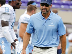 FILE - In this Sept. 8, 2018, file photo, North Carolina head coach Larry Fedora walks among his team prior to their game against the East Carolina, in Greenville, N.C. Fedora's Tar Heels play at No. 16 Miami on Thursday, Sept. 27, and will have nearly back nearly all the players who were suspended for selling-team issued shoes in the offseason.